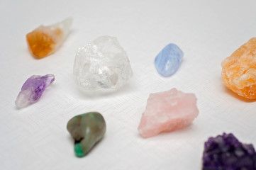 Healing crystals on a white table including: Amethyst Point and Cluster, Clear Quartz, Citrine, Calcite and Rose quartz. Gemstones are full of healing energy and good vibes.