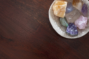 Healing crystals on a table including: Amethyst Point and Cluster, Clear Quartz, Citrine, Calcite and Rose quartz. Gemstones are full of healing energy and good vibes.