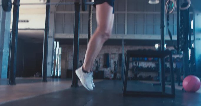 Young adult sporty Caucasian woman performing plyometric workout in functional gym, morning shot. 4K UHD