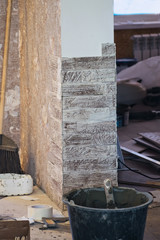 Mason putting decorative natural stones on a wall.