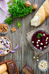 Salad from boiled beets, pieces of herring with red onion, nuts. Top view.