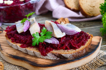Boiled grated beets, pieces of herring, red onions, nuts on whole grain bread. Delicious and healthy sandwich. Proper nutrition.