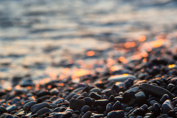 pebble stones on the sea beach, the rolling waves of the sea with foam © Wingedbull