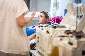 Young woman giving blood in a modern hospital