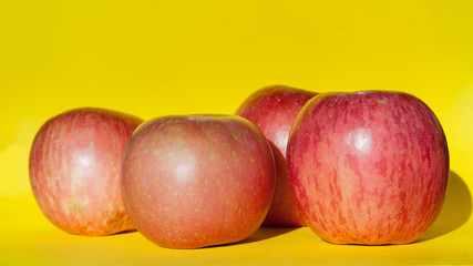 Pink apples on yellow background