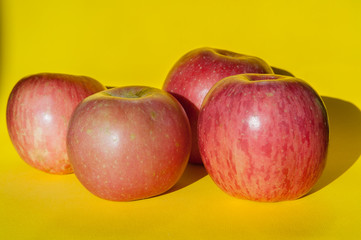 Pink apples on yellow backdrop