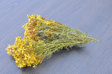 dry grass of St. John's wort, against the background of a gray wooden background.