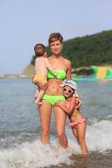 Fototapeta premium Mom is two kids on the sea
