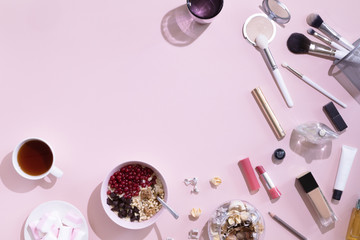 Flat lay with cup of tea or coffee, woman make up products on pink background, view from above.