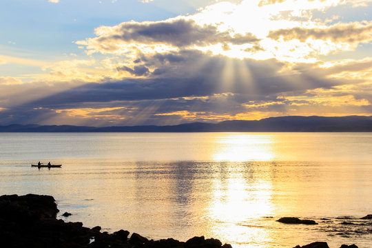 Sunset at the ocean in the evening with reflection of the sun in the water. Perfect for doing sport and working out, for example go kajaking with friends