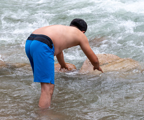 a man is bathing on a mountain river