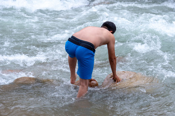 Fototapeta premium a man is bathing on a mountain river
