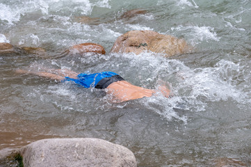 a man is bathing on a mountain river