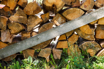 Firewood on the outdoor in summer. Photo of woodpile on the grass