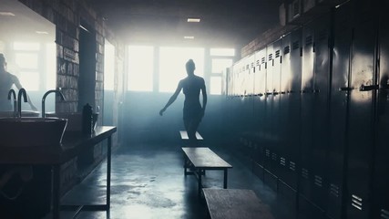 Caucasian female athlete taking off shirt in a gym locker room, angry, not satisfied with her workout results. 4K UHD WITH SOUND