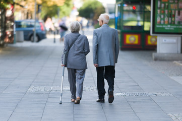 starsze osoby spacerują chodnikiem - obrazy, fototapety, plakaty