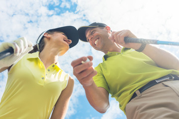Low-angle view portrait of a young woman smiling while looking at camera during professional golf...