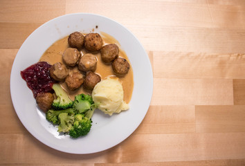 Swedish meatballs with mashed potato placed on the wooden table with blank space.
