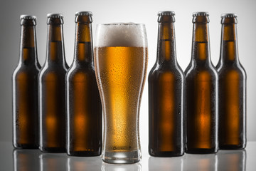 Beer glass between six bottles