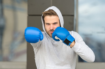 Strength and motivation. Sportsman concentrated training boxing gloves. Athlete concentrated face...