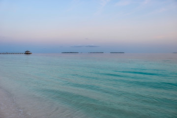 Dieses bild zeigt den t&uuml;rkisen ozean auf den malediven bei total ruhigem meer am fr&uuml;hen morgen. im hintergrund ist der bootsteeg zu sehen. Das bild wurde im s&uuml;d male atoll aufgenommen