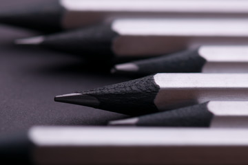 Fototapeta premium Gray sharpened pencils close-up on a dark background.