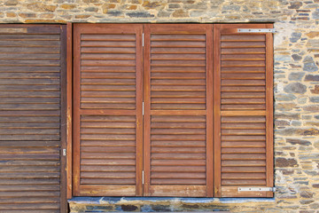Old wooden windows frame on stone wall in Spain