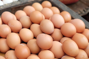 Pile of organic brown chicken eggs on wood tray for selling in the street market