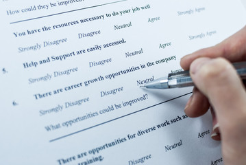 Respondent holding a pan in a hand and answeing questions in employee survey. Questions relating to...
