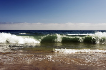 A view of a seascape, Pacific ocean, waves and foams and splash in Malibu, California