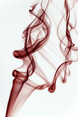 Red smoke on a white background and texture. Isolated colorful smoke in a studio space. Mystical artwork and shape.
