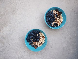 Healthy breakfast in a blue bowl. Oatmeal with blueberries and nut mix. Healthy food concept. Top view, side view. Space for text.