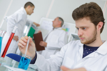 young scientist observing liquid reagent in laboratory