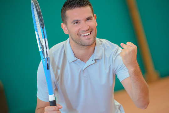 Man making victory gesture on tennis court