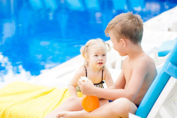 young children are resting by the pool