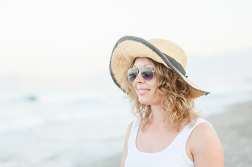 Portrait of happy smiling young woman with long hair on the beach and sea background