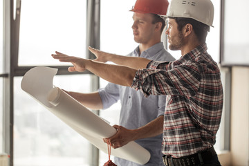 architect is pointing at building place to the customer. side view photo
