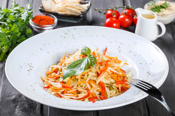 Fresh salad with apple, carrot, cabbage, celery and lemon on wooden background close up. Healthy food. Top view