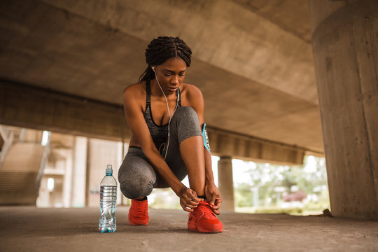 African American Woman Runner In Sportswear Tightening Shoe Lace