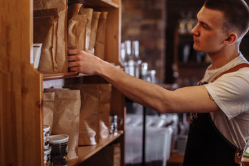 a handsome man is choosing the package with good coffee seeds
