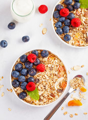 Homemade granola or oatmeal muesli with nuts, dried fruits and fresh berries. Healty diet breakfast, vegeterian food concept