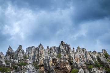 From below big cliffs and cloudy sky in nature in Cerro del Hierro, Seviile
