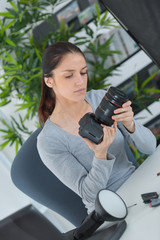 beautiful woman fixing retro camera