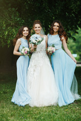 Obraz na płótnie Canvas Bride with bridesmaids on the park on the wedding day. 