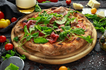 Stone Baked Pizza with prosciutto ham, arugula, parmesan and mozzarella cheese, beer
