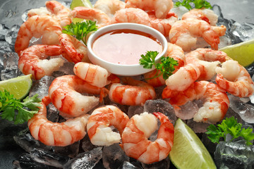 Tiger shrimps served on ice with lime wedges and sweet chilli dip