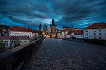 Fototapeta na wymiar View of the Lesser Bridge Tower of Charles Bridge in Prague at sunrise, Czech Republic, Europe. This bridge is the oldest in the city and a very popular tourist attraction.