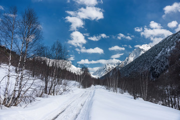 Fototapeta na wymiar A road in the winter Caucasus mountains. Alibek, Dombai, Russia.