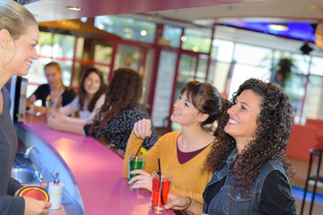 Women sat and bar talking to barmaid