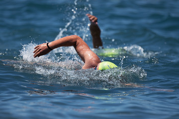 Swimmers swimming crawl in blue sea,training for triathlon - obrazy, fototapety, plakaty